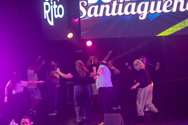 Gente bailando frente al escenario