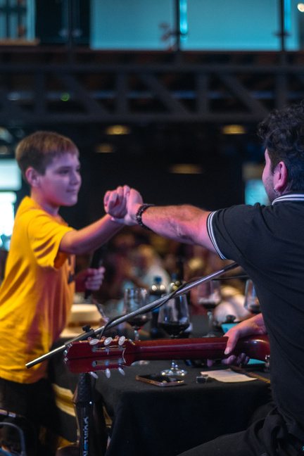 Un chico choca la mano con Ramón junto a las guitarras