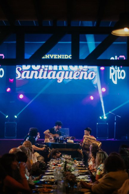Sala llena en un Domingo Santiagueño con el escenario y las mesas